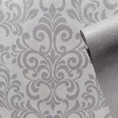 A glittery damask pattern wallpaper in grey and silver with a roll on the right-hand side.